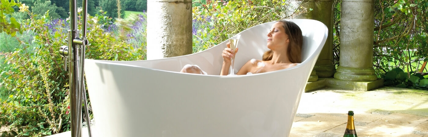 lifestyle image of a bath shown in a open bathroom setting with a girl in it